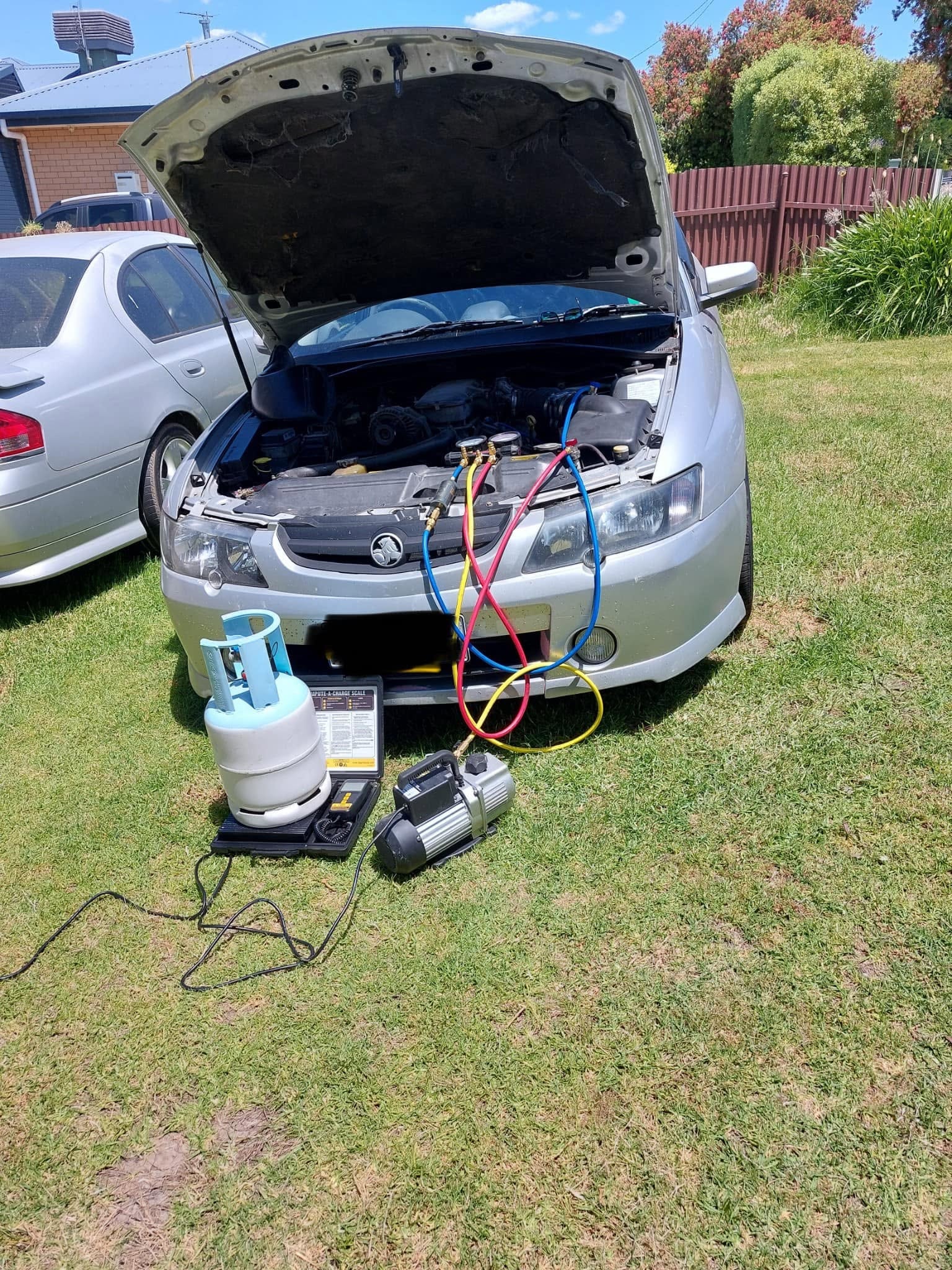 Holden AC regas service performed outdoors
